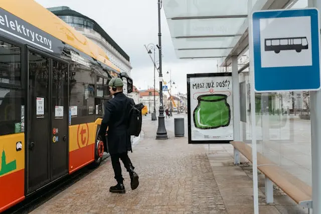 Bushaltestelle in Polen mit einem Bus, der an der Haltestelle wartet. Fahrgast steigt ein.
